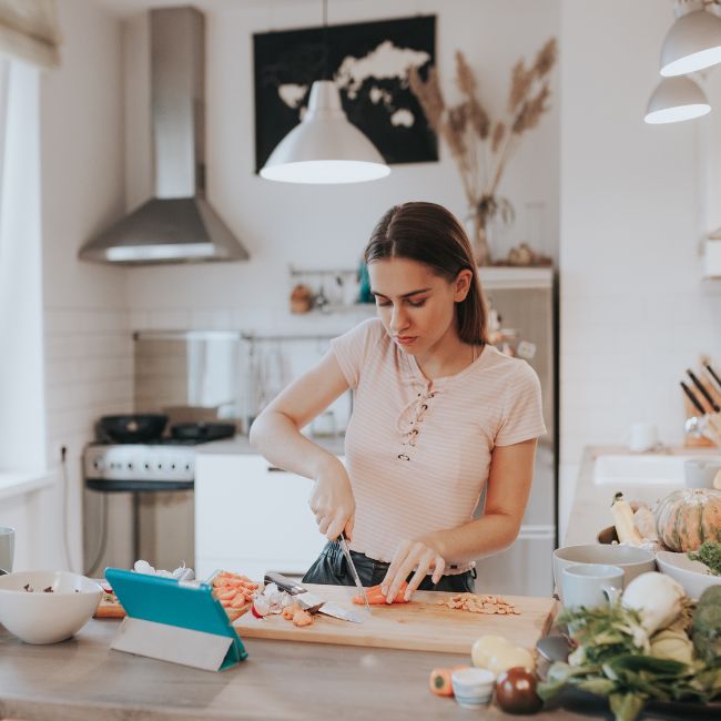 Life skills-Autism-Autistic - teenage girl in a kitchen cutting up food on a chopping board