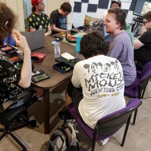 Group of participants at Ignition Gamers sitting around a table, deeply engaged in a gaming session. Highlighting gaming and communication skills for autistic individuals in a supportive and inclusive environment.